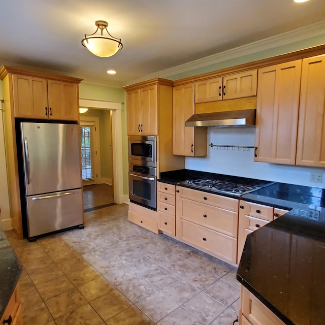 kitchen featuring stainless steel appliances, wall chimney range hood, dark stone counters, ornamental molding, and light brown cabinets