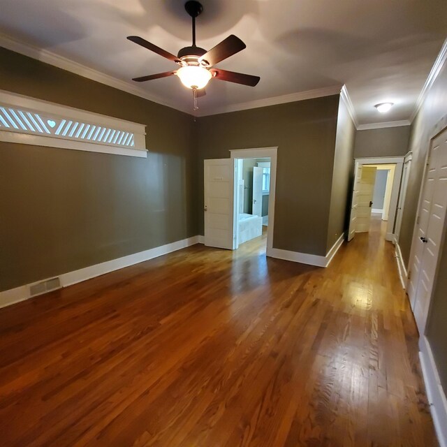 spare room with ceiling fan, crown molding, and wood-type flooring