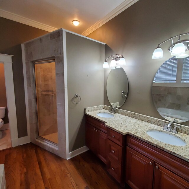 bathroom featuring a shower with shower door, vanity, crown molding, and hardwood / wood-style floors