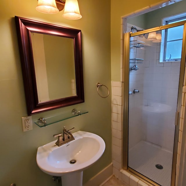 bathroom with sink and a shower with shower door