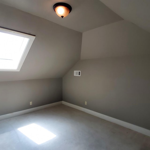 additional living space featuring vaulted ceiling with skylight