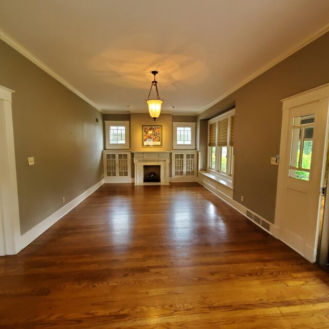 unfurnished living room featuring hardwood / wood-style floors and crown molding