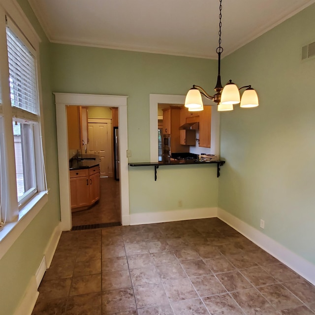 unfurnished dining area with tile patterned flooring, an inviting chandelier, and ornamental molding