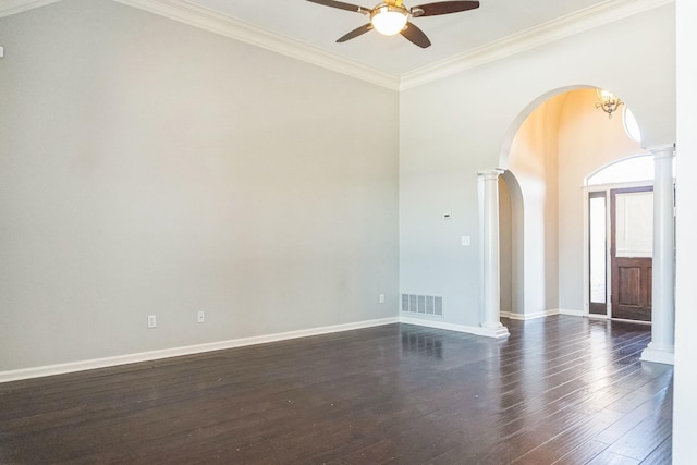 spare room featuring ornamental molding, dark hardwood / wood-style floors, ceiling fan with notable chandelier, and ornate columns