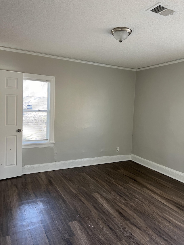 spare room featuring a textured ceiling, ornamental molding, and dark hardwood / wood-style floors