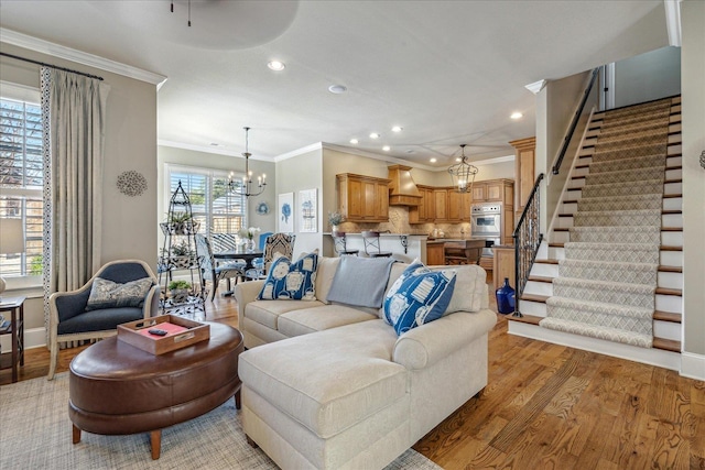 living room featuring ornamental molding, light hardwood / wood-style flooring, and a notable chandelier