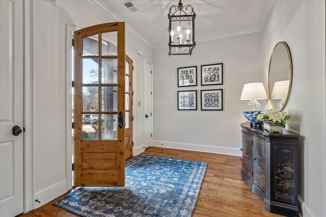 entryway featuring a chandelier, crown molding, and light hardwood / wood-style flooring