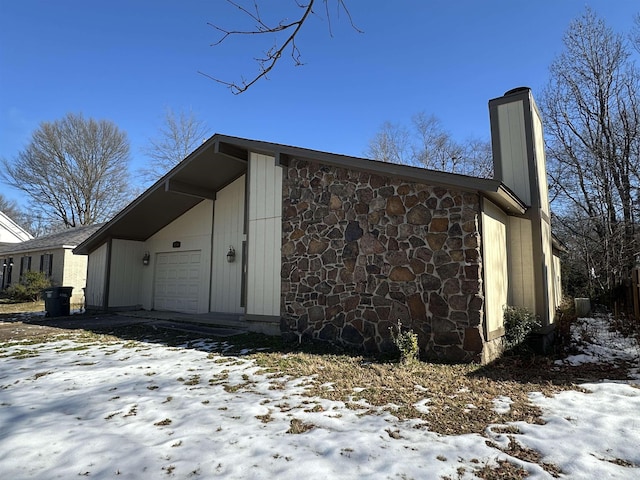 view of snowy exterior featuring a garage