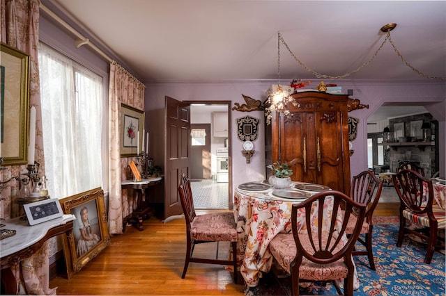 dining space with crown molding and light hardwood / wood-style flooring