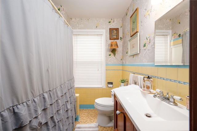 bathroom featuring curtained shower, tile walls, toilet, and vanity