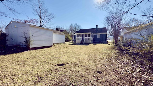 view of yard featuring a sunroom and an outdoor structure