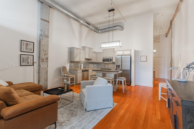 living room featuring a high ceiling and light hardwood / wood-style flooring