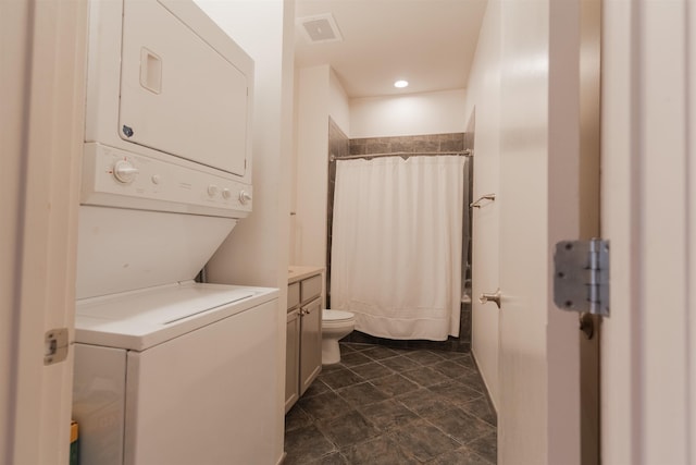 laundry area featuring stacked washer / dryer