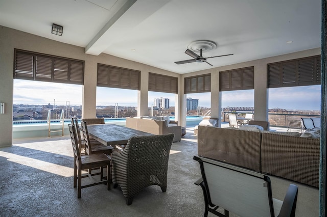 sunroom featuring ceiling fan and beam ceiling