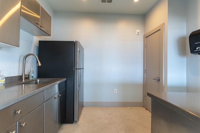 kitchen featuring sink, stainless steel fridge, and gray cabinets