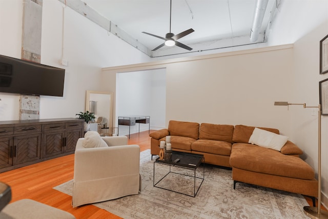 living room featuring ceiling fan, light wood-type flooring, and high vaulted ceiling