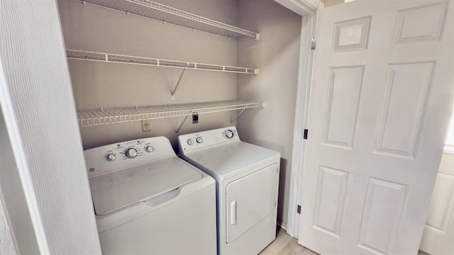 clothes washing area with light hardwood / wood-style floors and washing machine and clothes dryer