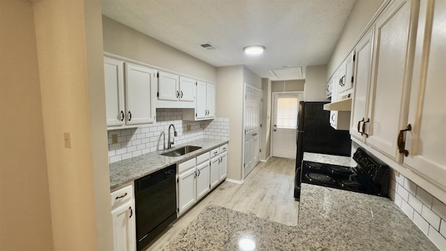 kitchen with white cabinetry, sink, light stone counters, and black appliances