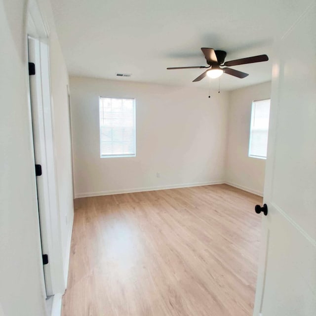 spare room featuring light wood-type flooring and ceiling fan