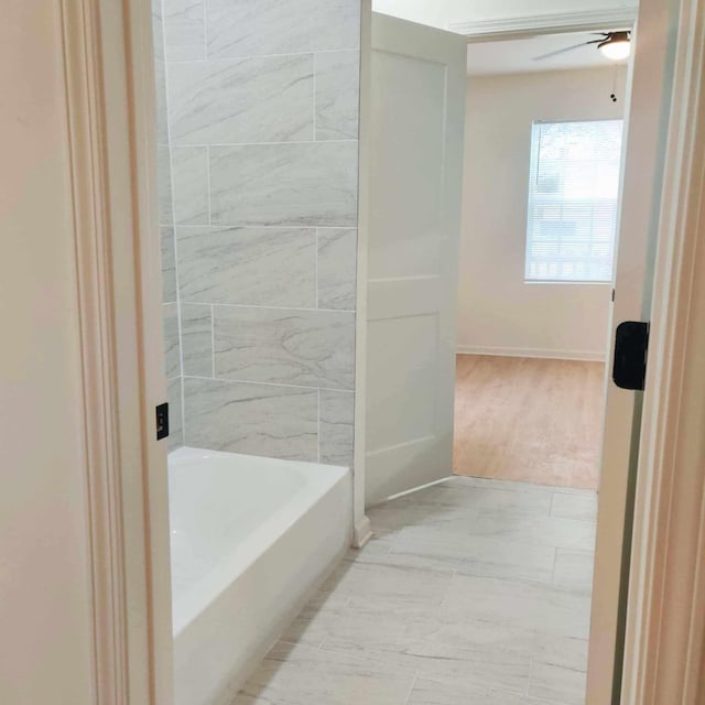 bathroom featuring ceiling fan and a bathtub