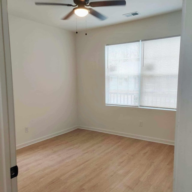 empty room featuring ceiling fan, light hardwood / wood-style flooring, and plenty of natural light