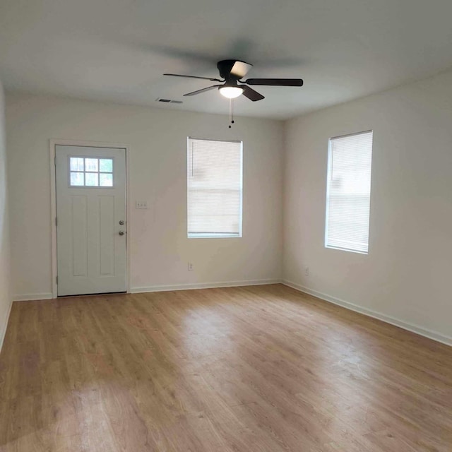 foyer entrance featuring a healthy amount of sunlight, ceiling fan, and light hardwood / wood-style floors