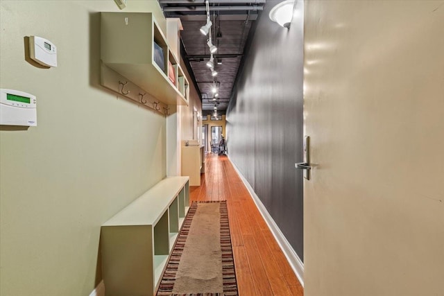 mudroom with a bowling alley, rail lighting, and wood-type flooring