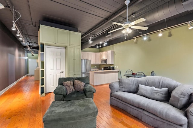 living room with ceiling fan and light hardwood / wood-style flooring