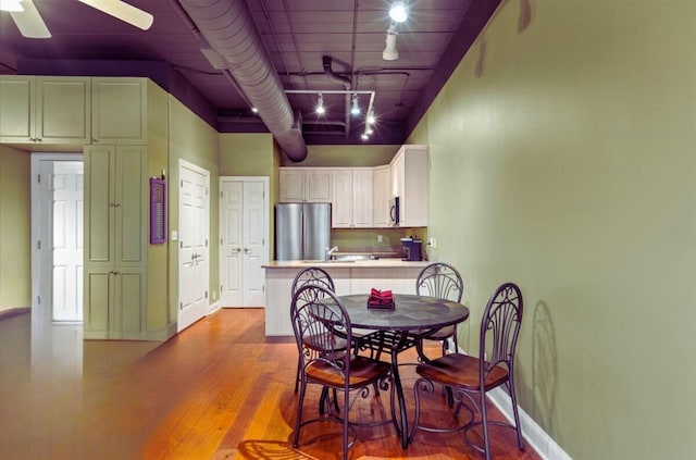 dining area featuring rail lighting, ceiling fan, and light hardwood / wood-style floors