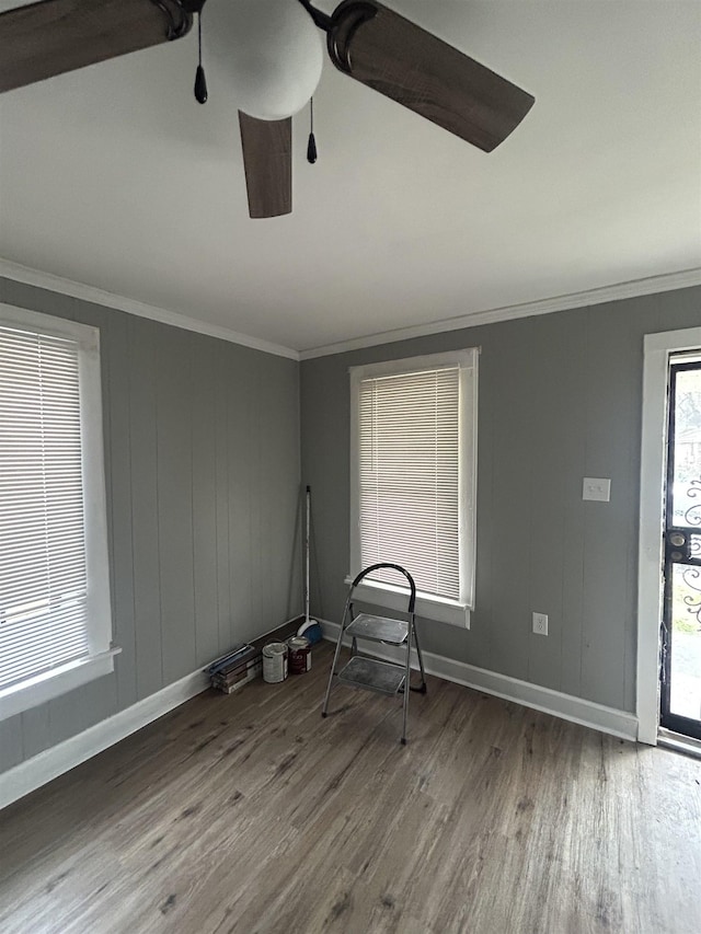 spare room featuring hardwood / wood-style flooring, ceiling fan, and crown molding