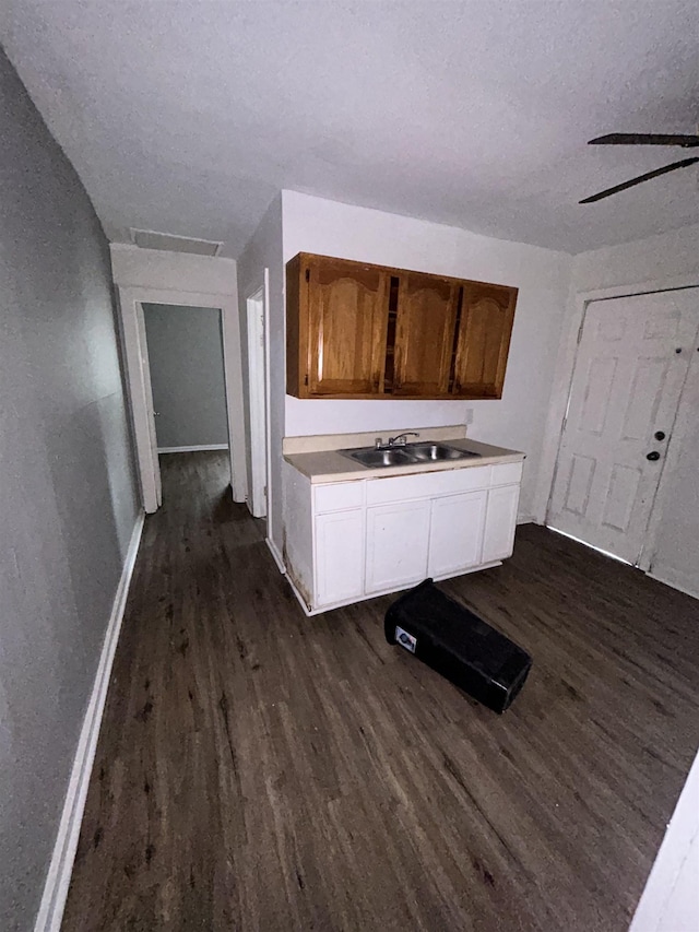 kitchen featuring sink, white cabinetry, a textured ceiling, and dark wood-type flooring