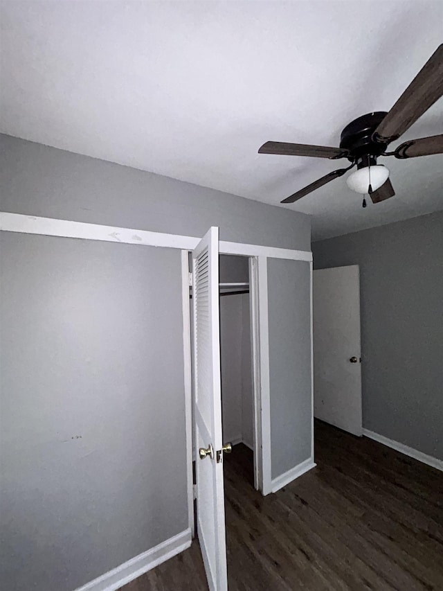 unfurnished bedroom with ceiling fan, a closet, and dark hardwood / wood-style floors