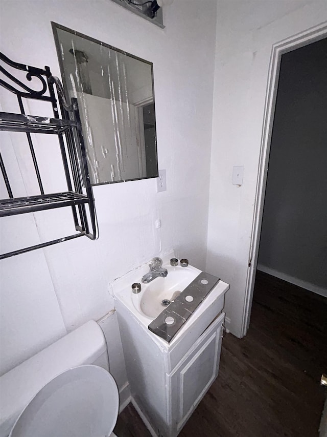 bathroom featuring wood-type flooring, vanity, and toilet