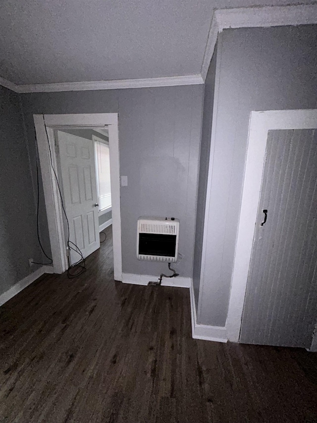 spare room with crown molding, dark hardwood / wood-style flooring, and heating unit