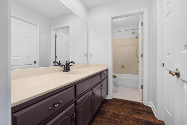 full bathroom with toilet, vanity, hardwood / wood-style flooring, and washtub / shower combination