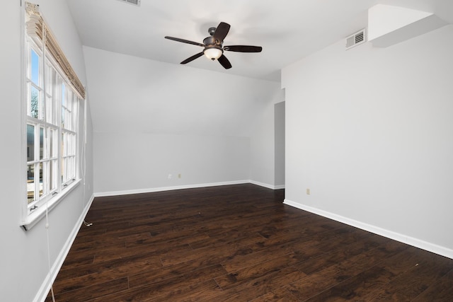 unfurnished room featuring vaulted ceiling, dark hardwood / wood-style flooring, ceiling fan, and a healthy amount of sunlight