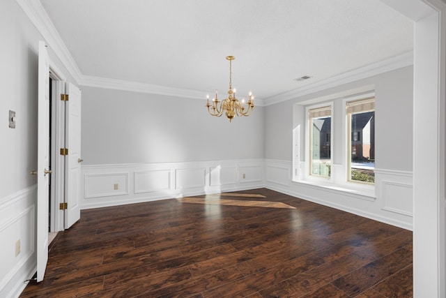 empty room featuring dark wood-type flooring, an inviting chandelier, and crown molding