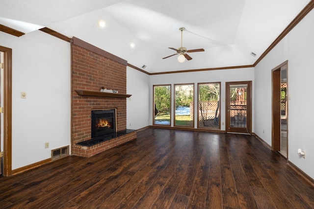 unfurnished living room with vaulted ceiling, a brick fireplace, dark hardwood / wood-style flooring, ornamental molding, and ceiling fan