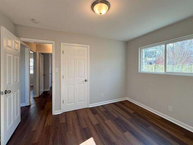 unfurnished bedroom featuring dark hardwood / wood-style flooring and a closet