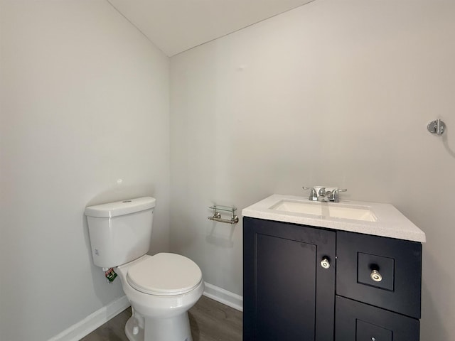 bathroom featuring toilet, vanity, and hardwood / wood-style flooring