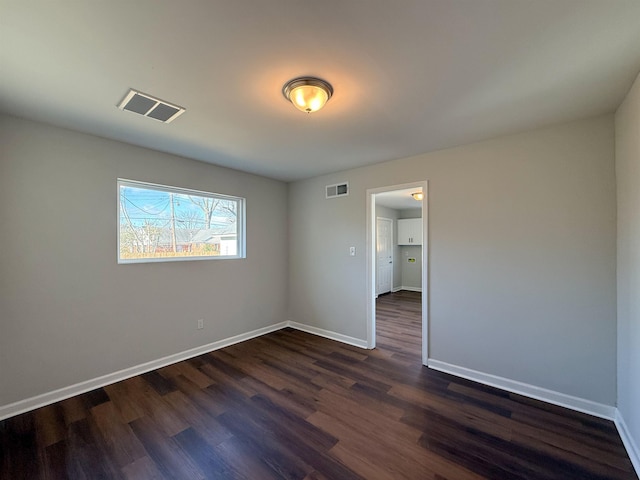 spare room featuring dark wood-type flooring