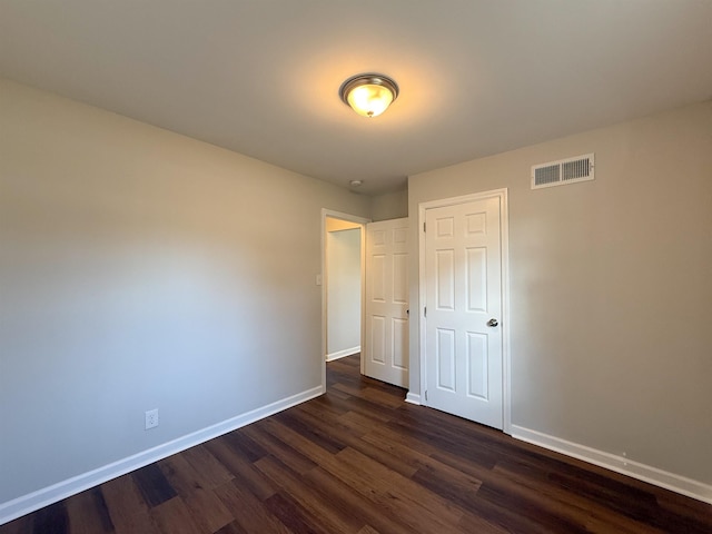 unfurnished bedroom with dark hardwood / wood-style floors