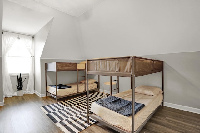 bedroom with lofted ceiling and dark hardwood / wood-style floors