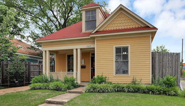 view of front of home with covered porch and a front lawn