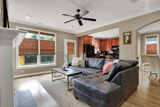 living room featuring crown molding, ceiling fan, and light hardwood / wood-style flooring