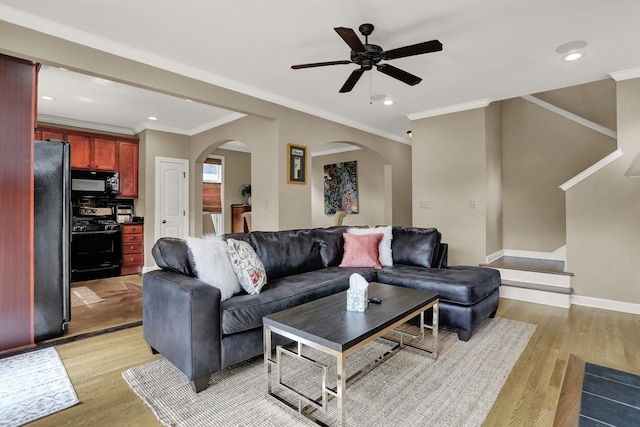 living room featuring ceiling fan, light hardwood / wood-style floors, and crown molding