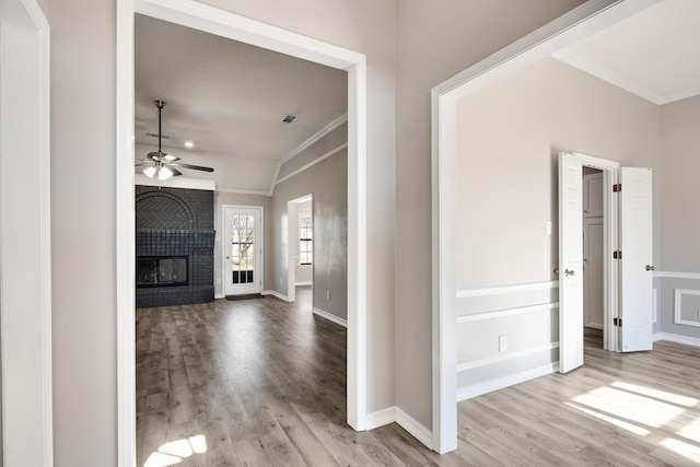 hall with light hardwood / wood-style flooring, vaulted ceiling, and crown molding