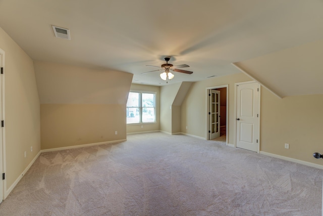 bonus room with vaulted ceiling, ceiling fan, and light carpet