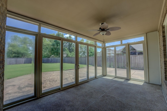 unfurnished sunroom with ceiling fan