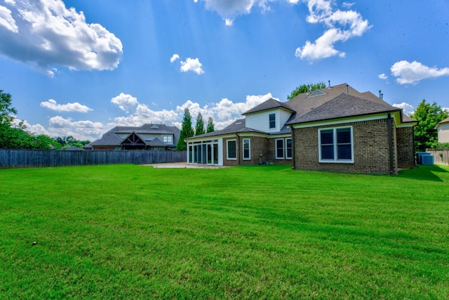 back of property with a patio area and a lawn